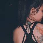 A girl choose Dubai for luxury tattoo showing her back tattoo